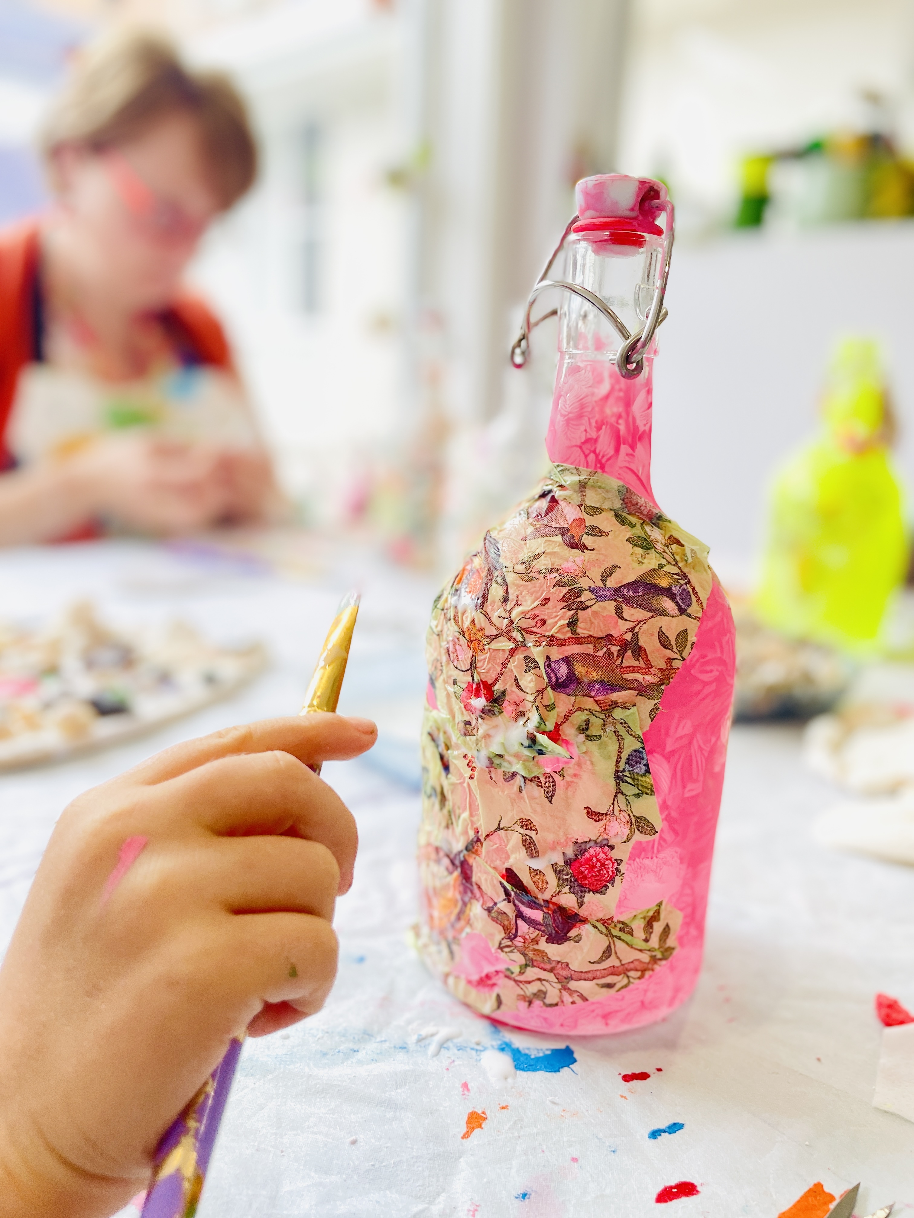 Craft workshop with adults making decoupage bottles